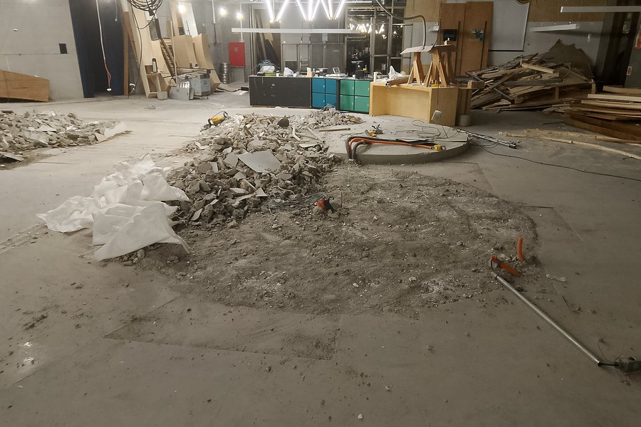 Demolição controlada de piso em andar corporativo, com o escritório em funcionamento ao redor