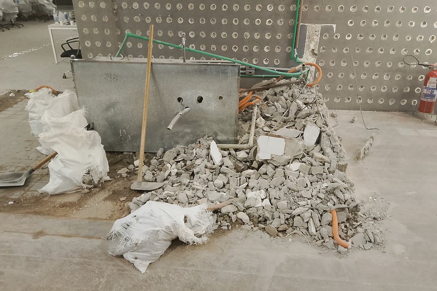 Demolição de piso junto ao hall dos elevadores, com o prédio em funcionamento