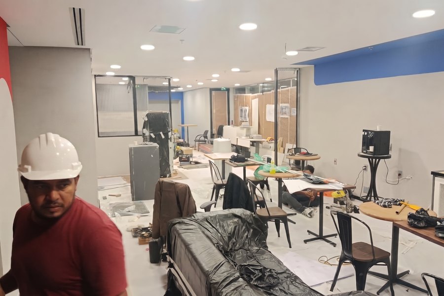 Equipe trabalhando em várias frentes simultâneas no andar corporativo