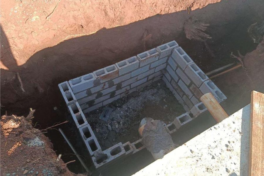 Caixa de passagem em bloco estrutural no fundo da vala