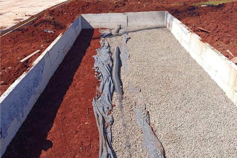 Dreno com manta geotêxtil e brita entre paredes de concreto