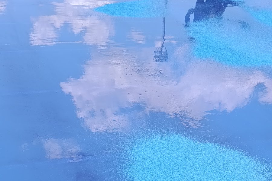 Close da superfície azul recém-aplicada refletindo o céu