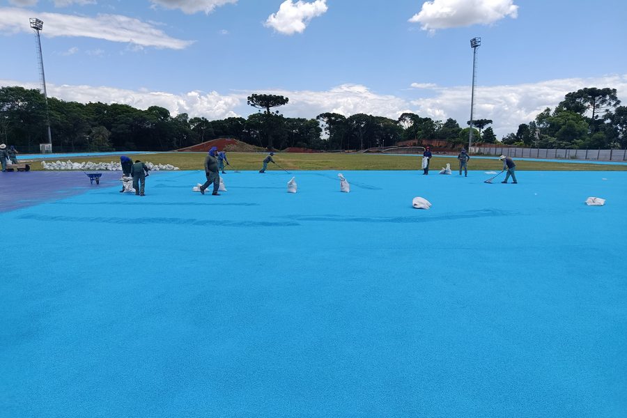 Equipe aplicando a camada azul-clara de acabamento