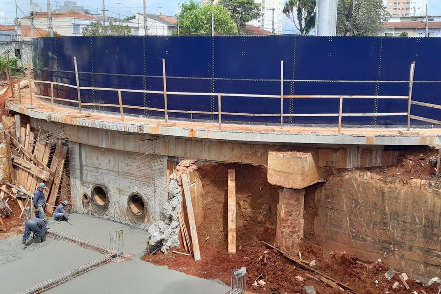 Equipe concretando a laje de fundo do reservatório junto ao muro de contenção