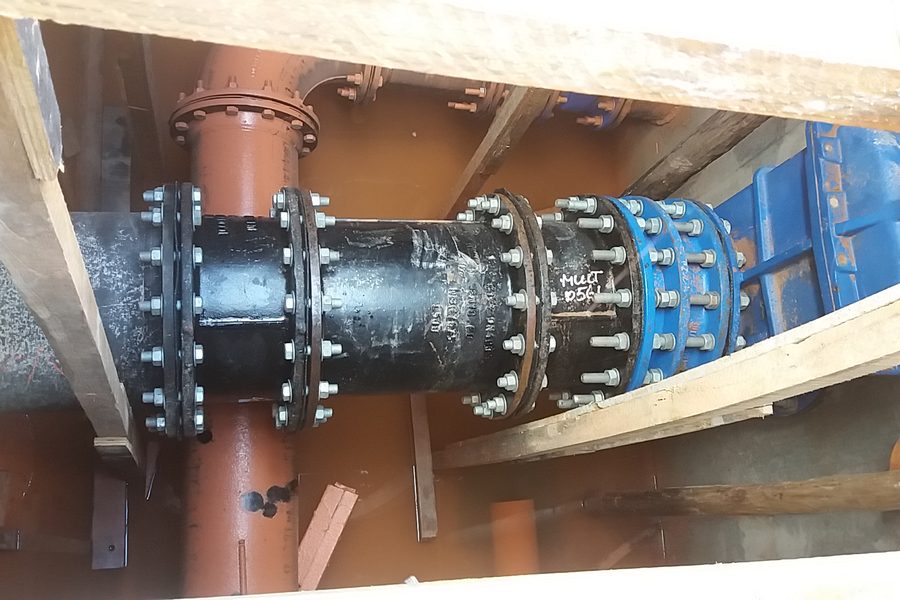 Tubulação flangeada com válvula azul montada em vala escorada