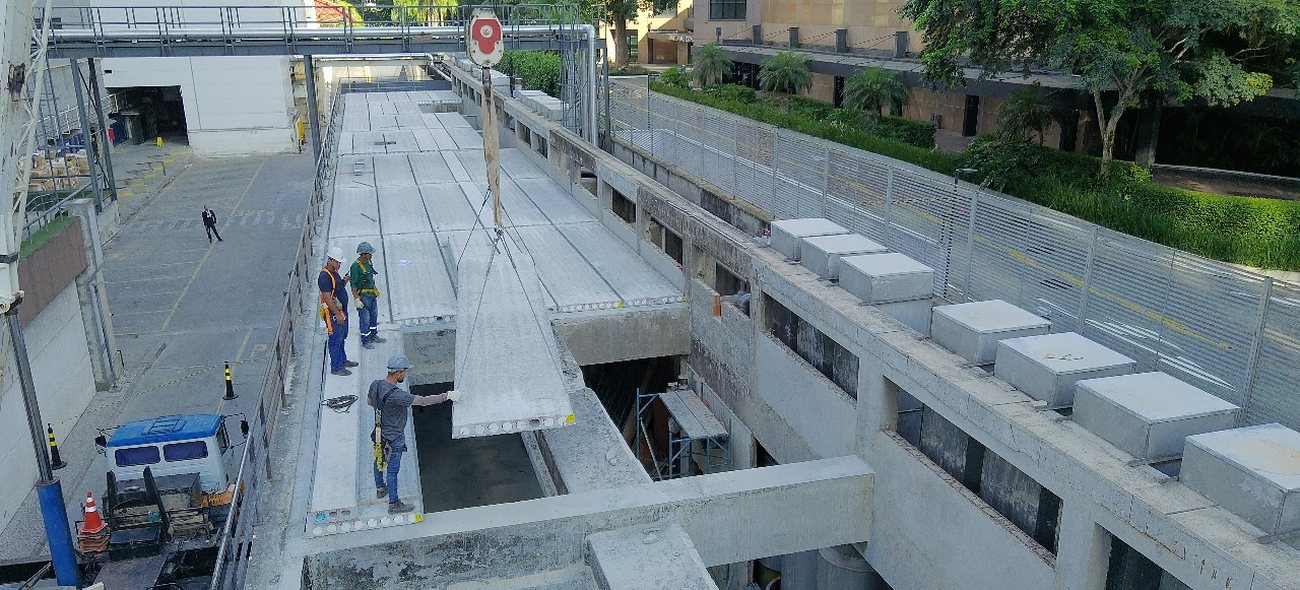 Obra industrial de grande porte com estrutura de concreto e equipe em campo