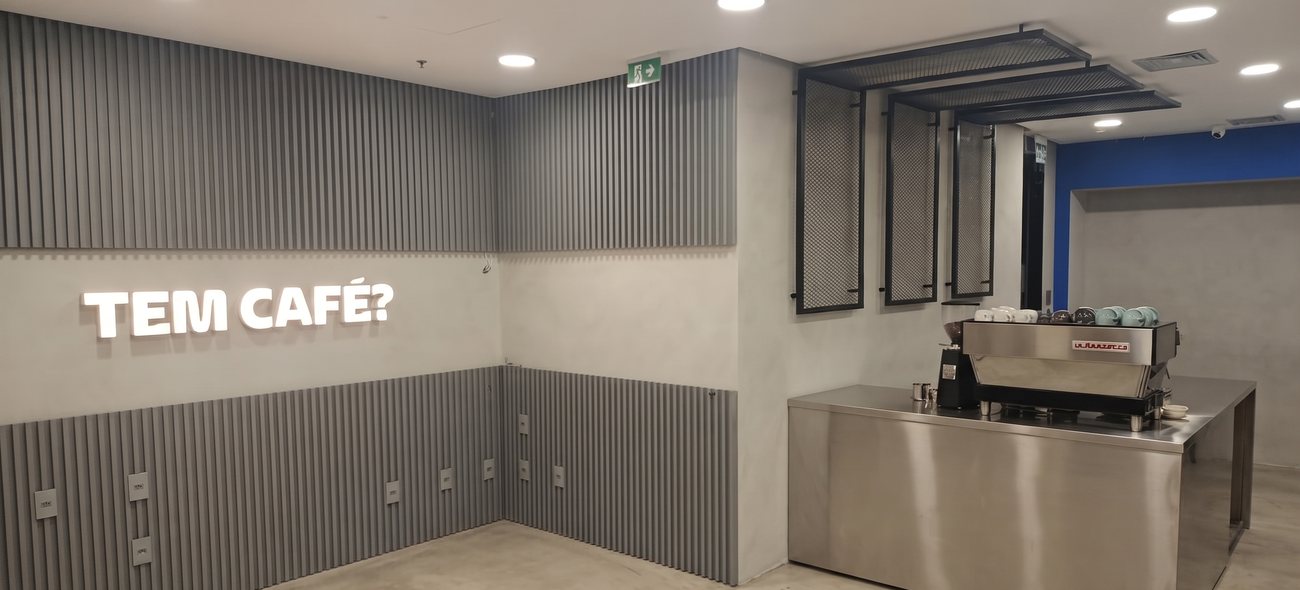 Cafeteria corporativa entregue, com painel ripado e comunicação visual instalada